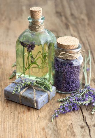 essential lavender oil, herbal soap and bath salt with fresh flowers on wooden background